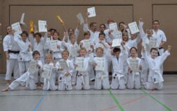 Foto einer Gruppe erfolgreicher TSV Karate-Kids nach Gürtelprüfung mit Urkunde