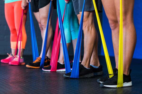Athletes exercising with resistance band in gym