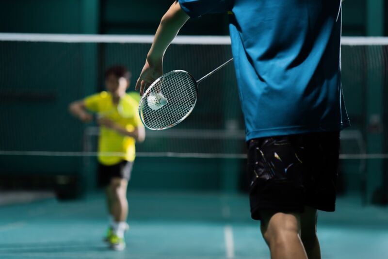 badminton player is hitting in court